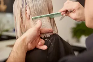 hairdresser-combing-and-cutting-woman-hair-in-beauty-salon(1)
